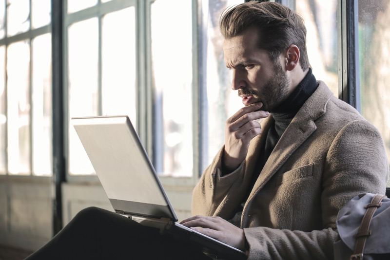 photo man on laptop looking concerned