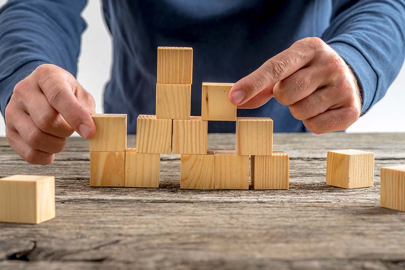 stockphoto male hands stacking wooden cubes on desk