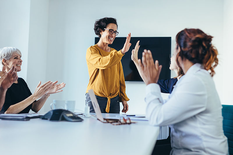 stockphoto woman in yellow leading meeting with other women