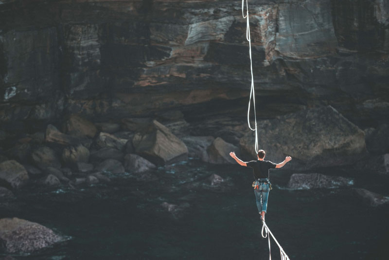 stockphoto person walking tightrope over canyon