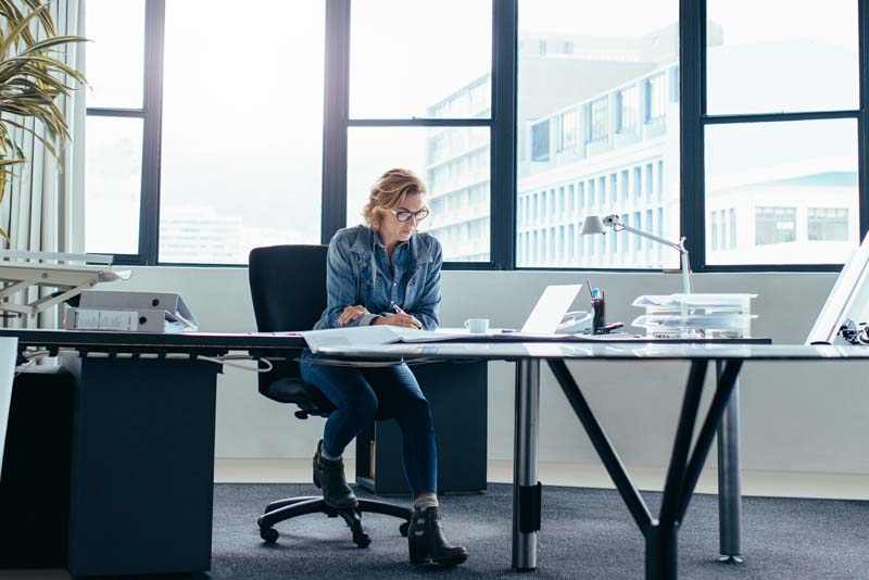 stockphoto woman at desk with windows behind